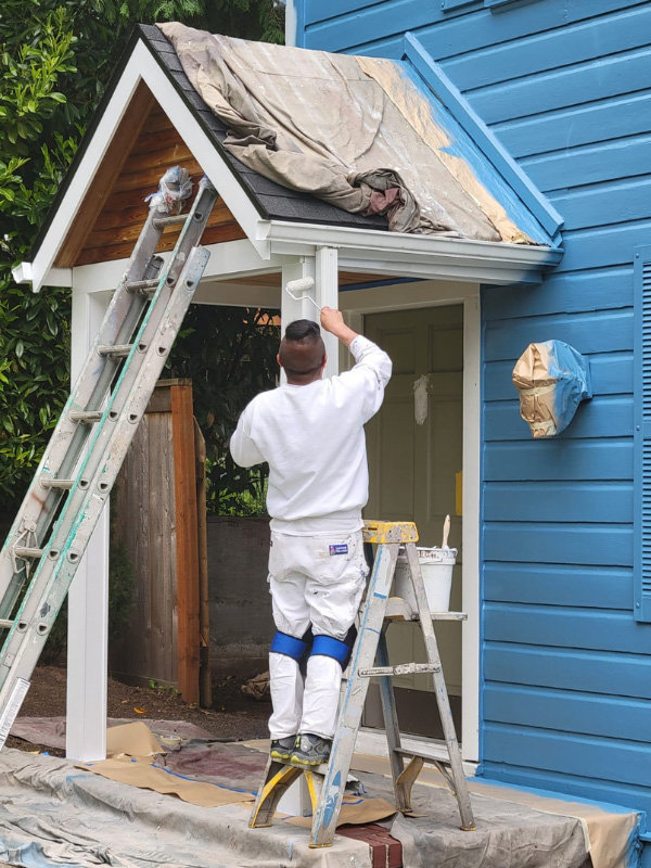 professional-jk-paint-crew-member-painting-blue-house