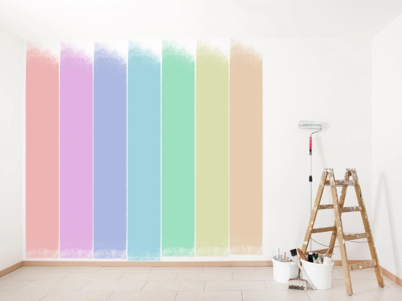 different-colors-painted-on-wall-paint-roller-brush-and-ladder-in-corner-of-room