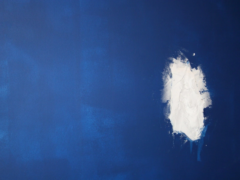 royal-blue-painted-wall-with-hole-that-has-been-filled-with-putty-before-new-paint0is-applied