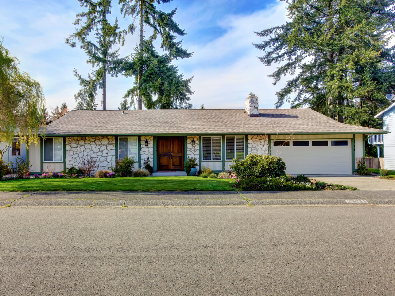 cream-colored-house-with-stone-veneer-siding-and-dark-green-house-trim