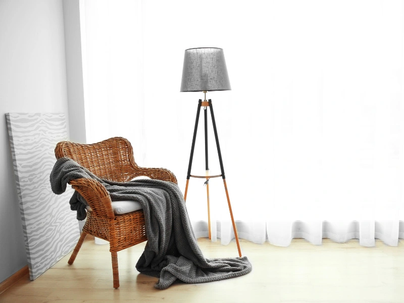 new-floor-lamp-next-to-wicker-chair-with-gray-throw-blanket-draped-over-it