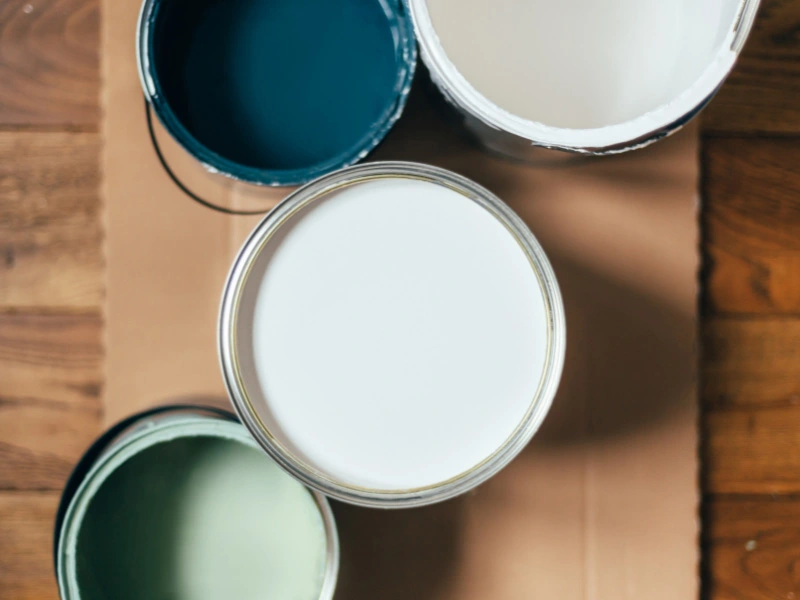 open-paint-cans-sitting-on-cardboard-on-floor