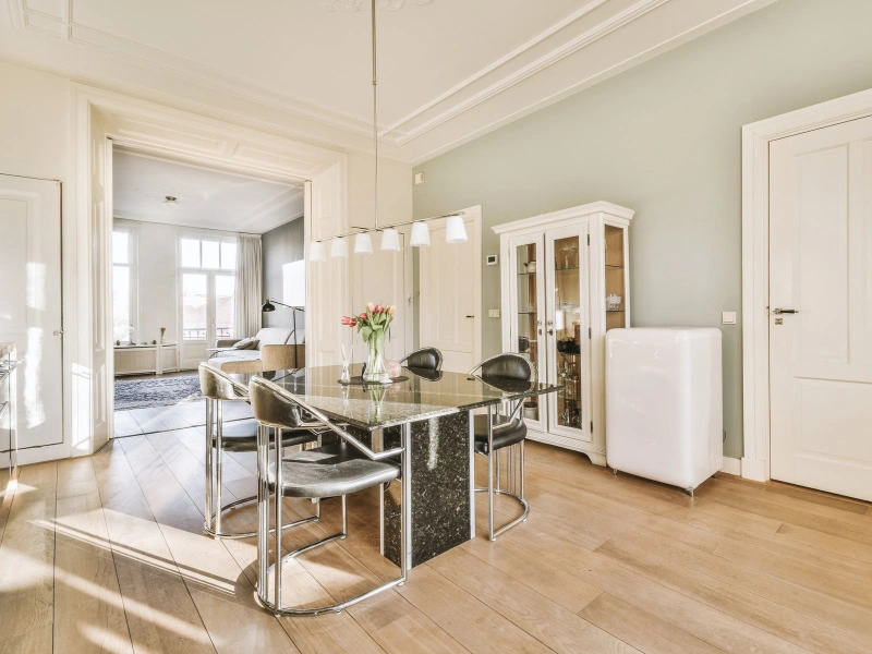 pastel-sage-green-painted-dining-area-with-black-accent-dining-table-and-chairs