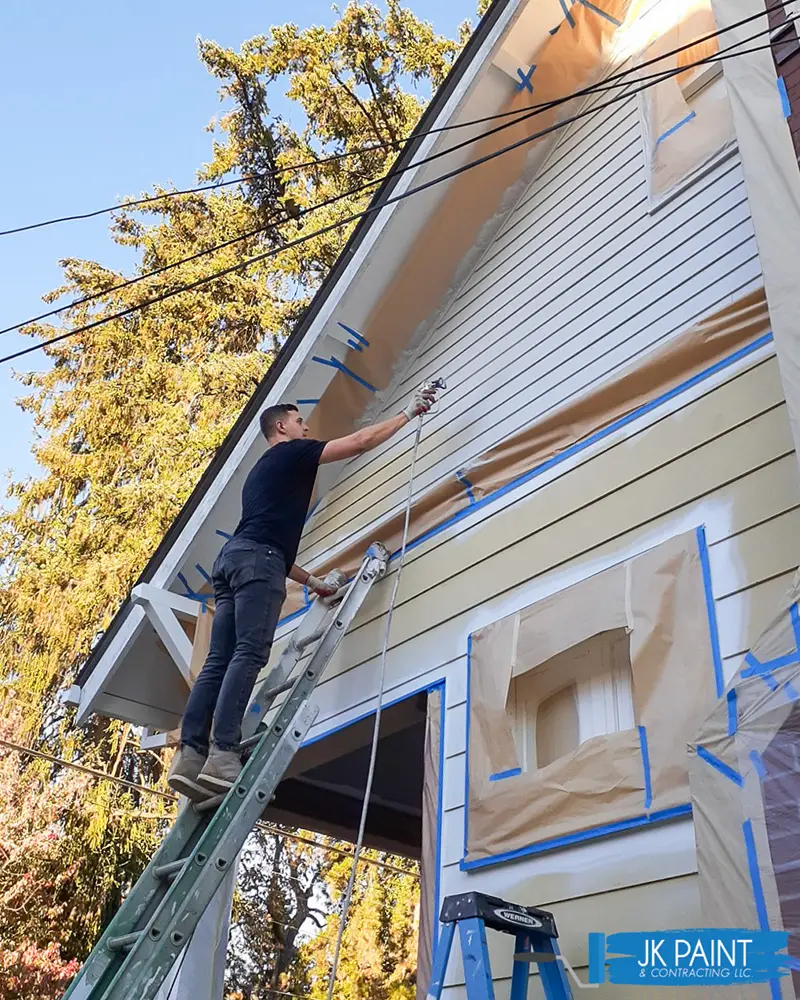 Joe-Kelley-on-a-ladder-painting-a-formerly-yellow-house-to-a-base-white