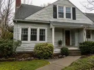 aging-exterior-paint-on-older-portland-home an exterior painting contractor caulking a house