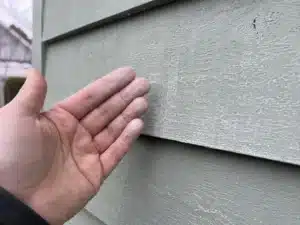 chalky-exterior-paint-residue-on-house-siding an exterior painting contractor caulking a house