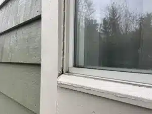 cracked-caulking-around-exterior-window-portland-home an exterior painting contractor caulking a house