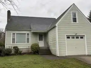 faded-exterior-paint-on-portland-metro-home an exterior painting contractor caulking a house